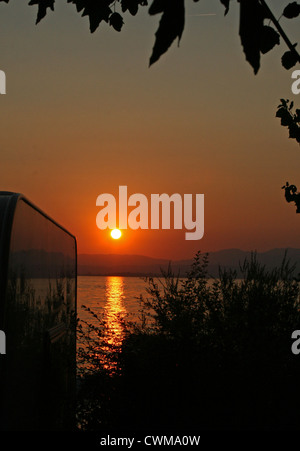 Wohnwagen geparkt neben Pacengo Gardasee, Camping Lido Italien bei Sonnenuntergang Stockfoto