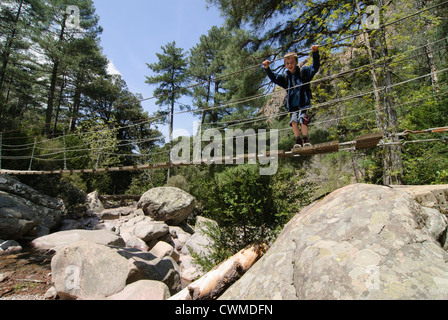 Junge auf einer Hängebrücke, Wandern in den Bergen von Korsika Stockfoto