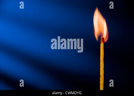 Flamme der Streichholz vor blauem Hintergrund Stockfoto