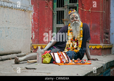 Behinderte Sadhu Verkauf Angebote wie Girlanden der Blumen für den Tempel in Varanasi, Uttar Pradesh, Indien gemacht Stockfoto