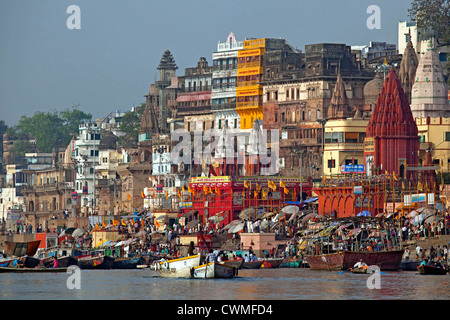 Pilger besuchen die Heilige Stadt und bunten Ruderboote auf den Ganges in Varanasi, Uttar Pradesh, Indien Stockfoto