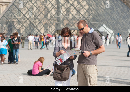 Paris, Frankreich - Juli 2012 - paar Touristen auf der Suche auf Karte der Umgebung von Louvre Museum. Stockfoto