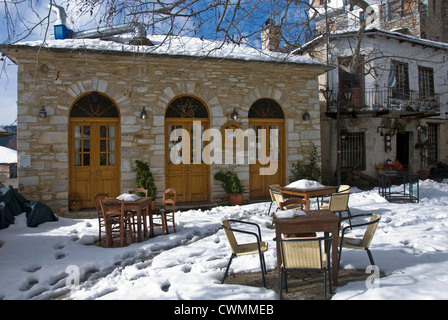 Taverne in der Berg-Dorf Pinakates mit schneebedeckten Tabellen im Winter (Halbinsel Pilion, Thessalien, Griechenland) Stockfoto