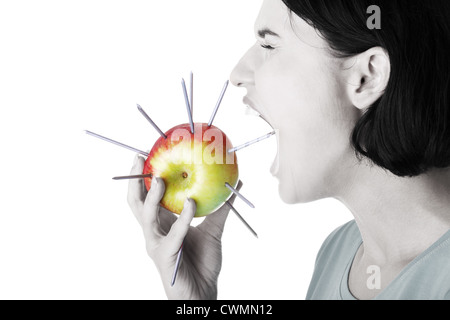 Hals-Schmerzen-Konzept. Frau zu essen Apfel mit Nägeln. Stockfoto
