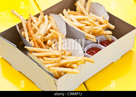 Teile der französische Pommes Frites mit Ketchup in Karton zum mitnehmen Stockfoto