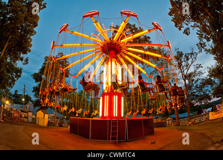 25. August 2012 - Middlebury, Connecticut, USA-Menschen Spinnen auf bunt beleuchteten Schaukel fahren in der Nacht, im Quassy Amusement Park. Stockfoto