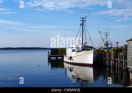 Ein Fischerboot gefesselt in einem Kai mit Hummerfallen auf der Anklagebank warten auf die nächste Saison Stockfoto