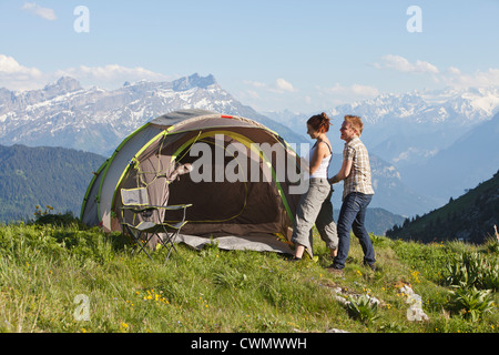 Schweiz, Leysin, Wanderer pitching Zelt auf der Wiese Stockfoto