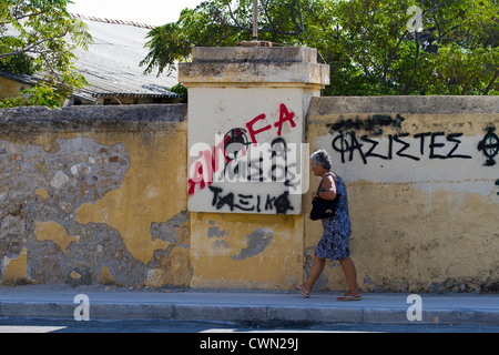Graffiti in Rhodos-Stadt an den Wänden in die Stadt führenden Zentrum als Frau vorbei, Ägäis, mediterran geht Stockfoto