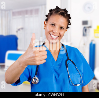 junge afrikanische amerikanische Krankenschwester aufzugeben Daumen in Spitalabteilung Stockfoto