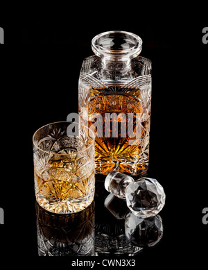 Whiskeyglas Kristall und Flasche auf dunklem Hintergrund Stockfoto