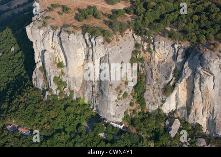LUFTAUFNAHME. Massive Kalksteinklippe, die die Eremitage von Bismantova in den Schatten stellt. Pietra di Bismantova, Castelnovo ne' Monti, Emilia-Romagna, Italien Stockfoto