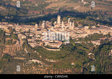 LUFTAUFNAHME. Mittelalterliche Stadt auf einem Hügel mit ihren vielen Türmen, die vor Jahrhunderten von reichen Familien erbaut wurden. San Gimignano, Provinz Siena, Toskana, Italien. Stockfoto