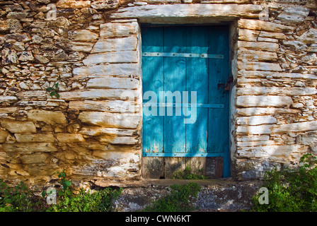 Fassade von einer alten Steinhaus mit verwitterten Holztüre auf Pilion Halbinsel, Thessalien, Griechenland Stockfoto