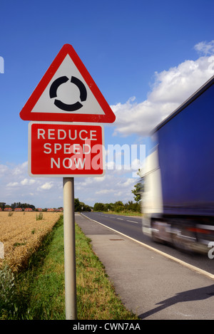 LKW vorbei verringern Geschwindigkeit jetzt Warnung Zeichen und Kreisverkehr vor Großbritannien Stockfoto