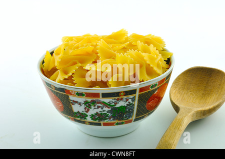 Keramikschale dekoriert mit farbigen voll Schmetterling-förmige Pasta, vor einem weißen Hintergrund Stockfoto