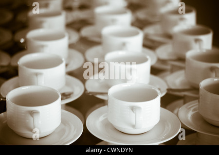 Viele Reihen von reinen weißen Tasse und Untertasse in Vintage-retro-Stil gestaltet. Hinweis: das Bild enthält Getreide als Bestandteil des Stils. Stockfoto