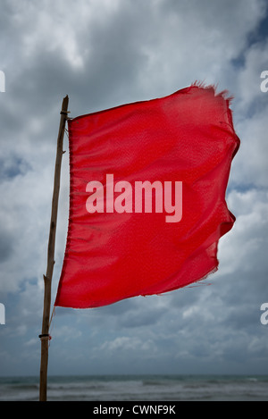 Rote Warnung Flagge an einem Strand mit Gewitterwolken auf Hintergrund Stockfoto