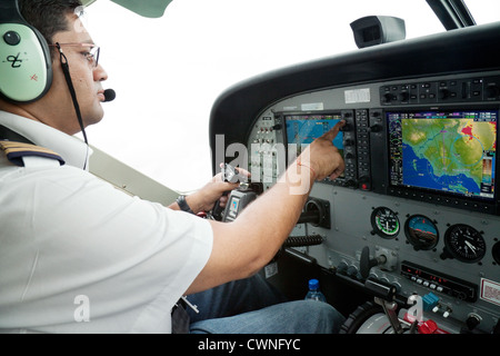 Pilot im Cockpit an den Schalthebeln der eine Cessna Caravan Kleinflugzeug Flugzeug, Tansania, Afrika Stockfoto