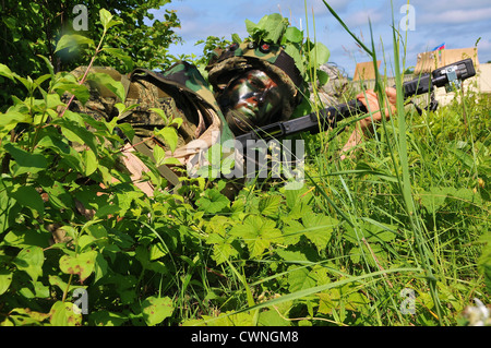 Kroatische Bodentruppen Soldat mit gemalten schwarzen Gesicht ändert seine Zeitschrift während einer Feld-Übung im Rahmen der unmittelbaren Reaktion 2012, einer US Army/Europe-geführten gemeinsamen Feld Übung 6. Juni 2012 in Slunj, Kroatien. Stockfoto