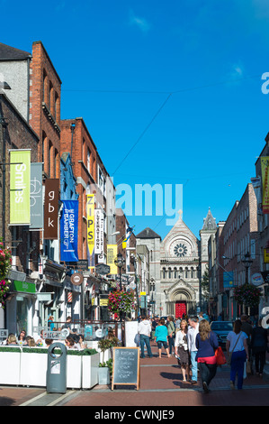 Eine geschäftige Anne Street South mit St. Ann's Church of Ireland nach hinten. Dublin, Irland. Stockfoto