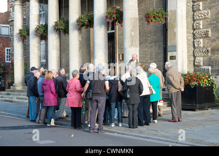 Reiseleiter und Touristen versammelt hören Stockfoto