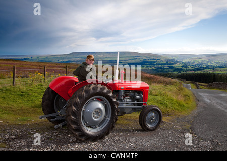 Richard Narbe mit rot Vintage Massey Ferguson auf dem Bauernhof 35 X 1962 Traktor, Redmire Grinton Mauren zu Reeth, North Yorkshire Dales, Richmondshire, Stockfoto