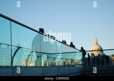 Massen von Pendlern, die Wogen über die Millennium Brücke; St. Pauls-Kathedrale im Hintergrund. London, England. Stockfoto