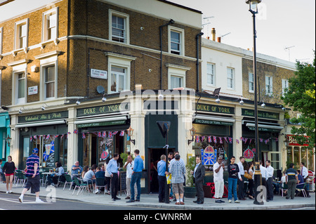 Menschenmenge im Freien, die sich bei warmem Wetter im Londoner Pub Duke of York in St John's Wood, Großbritannien, treffen und draußen trinken Stockfoto