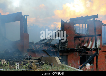 Haus innen durch intensives Feuer zerstört. Flammen, Rauch und Funken verschlingt das Innere eines Hauses. Stockfoto