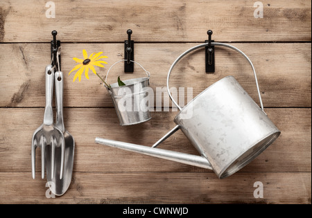 Garten-tools hängen und Gießkanne an Schuppen Tür mit Vintage-Look Stockfoto