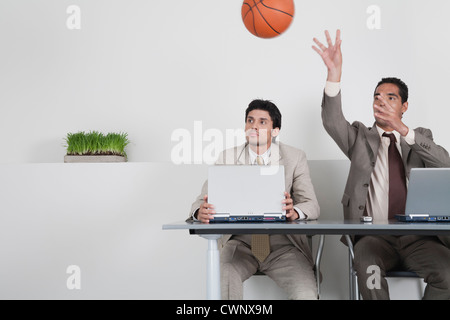 Junger Geschäftsmann beobachten Kollegen werfen basketball Stockfoto