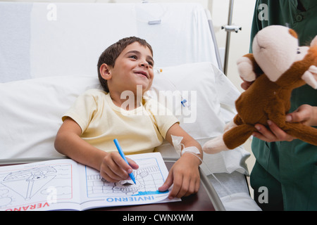 Krankenschwester geben Kranken jungen gefüllte Tier im Krankenhaus beschnitten Stockfoto