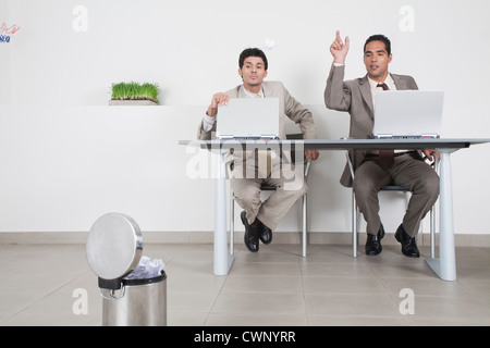 Geschäftsmann gerade Kollegen werfen Papier Ball im Mülleimer Stockfoto