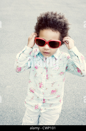 Kleines Mädchen Sonnenbrille aufsetzen Stockfoto