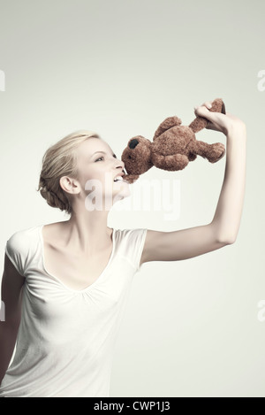 Beißende Teddybär junge Frau, Porträt Stockfoto