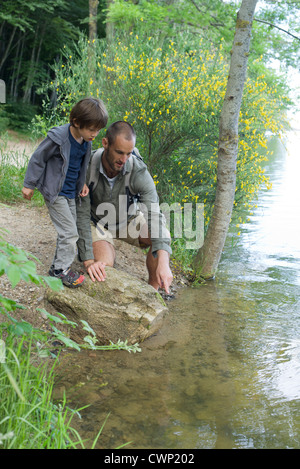 Vater und Sohn durch Fluss Stockfoto