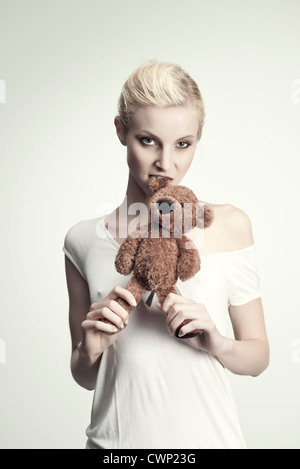 Beißende Teddybär junge Frau, Porträt Stockfoto