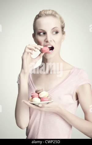 Junge Frau mit Platte Makronen, Porträt Stockfoto