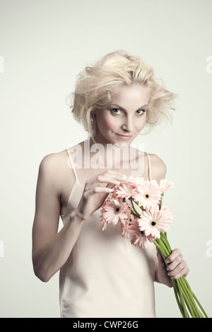 Junge Frau mit Haufen von Gerbera daisies Stockfoto