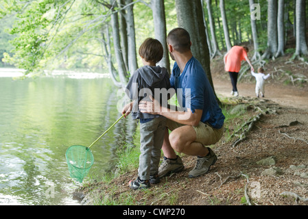 Vater und Sohn im Wald, beide auf der Suche nach Fischen Stockfoto