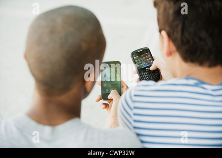 Junge Männer, die Nutzung von Mobiltelefonen, Rückansicht Stockfoto