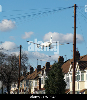 Flugzeug fliegen über Dächer in der Nähe von Heathrow Airport, London, UK. Stockfoto