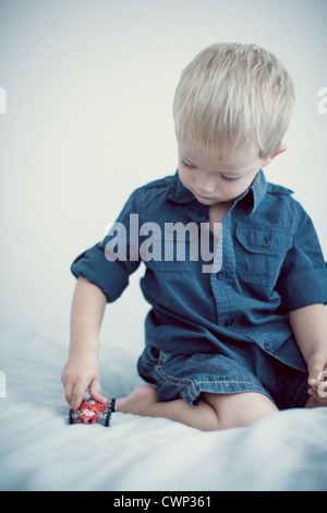 Kleinkind spielt mit Spielzeug-Auto Stockfoto