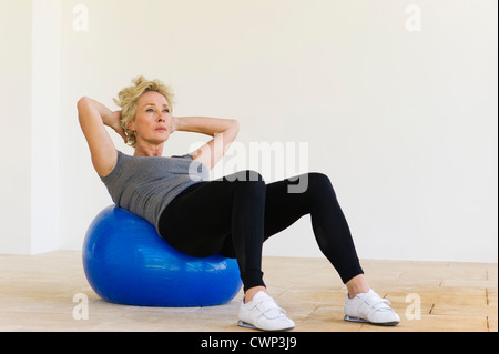Reife Frau Sit auf Fitness-ball Stockfoto