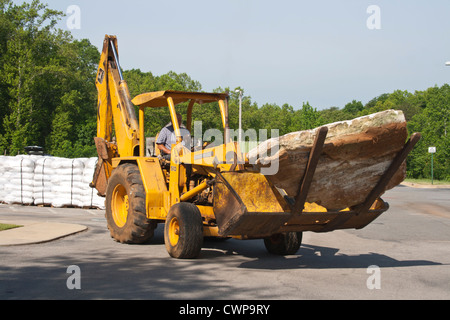 Mann mit Hacke zurück geht großen Felsen. Stockfoto