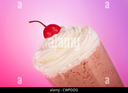 Lecker Milchshake isoliert auf rosa Hintergrund, süße Vanille Eis mit roten frische Kirschen, kalte Schokolade Getränk Stockfoto