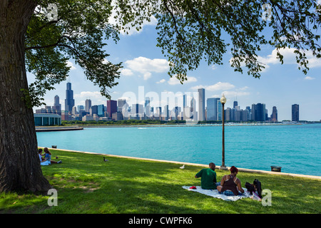 Menschen picknicken vor der Skyline der Stadt angesehen von den Museum Campus im Grant Park, Chicago, Illinois, USA Stockfoto