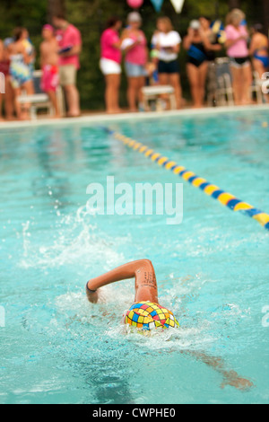 Jugend-Schwimmer schwimmt Freestyle und erreicht für Wand beim Schwimmen treffen Stockfoto