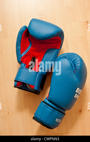 Paar blaue Boxhandschuhe auf dem Boden einer Turnhalle Stockfoto